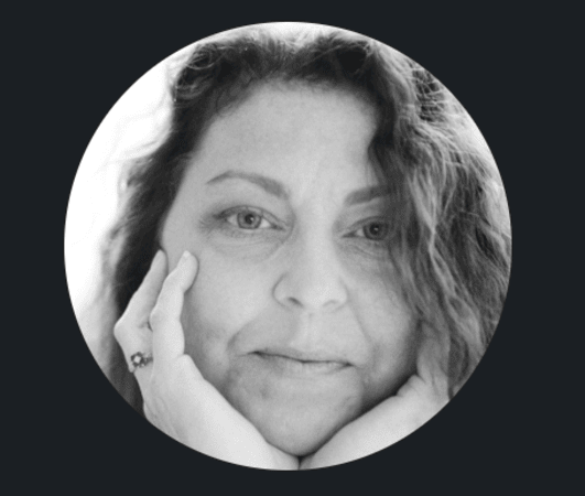 Professional Female Voiceover Artist, Birmingham, Alabama A close-up headshot of Jennifer Skates, professional voiceover artist from Birmingham, Alabama, with her hands framing her face and smiling.